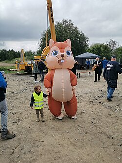 Ein aufgeblasenes Eichhörnchen Kostüm und ein kleiner Junge.